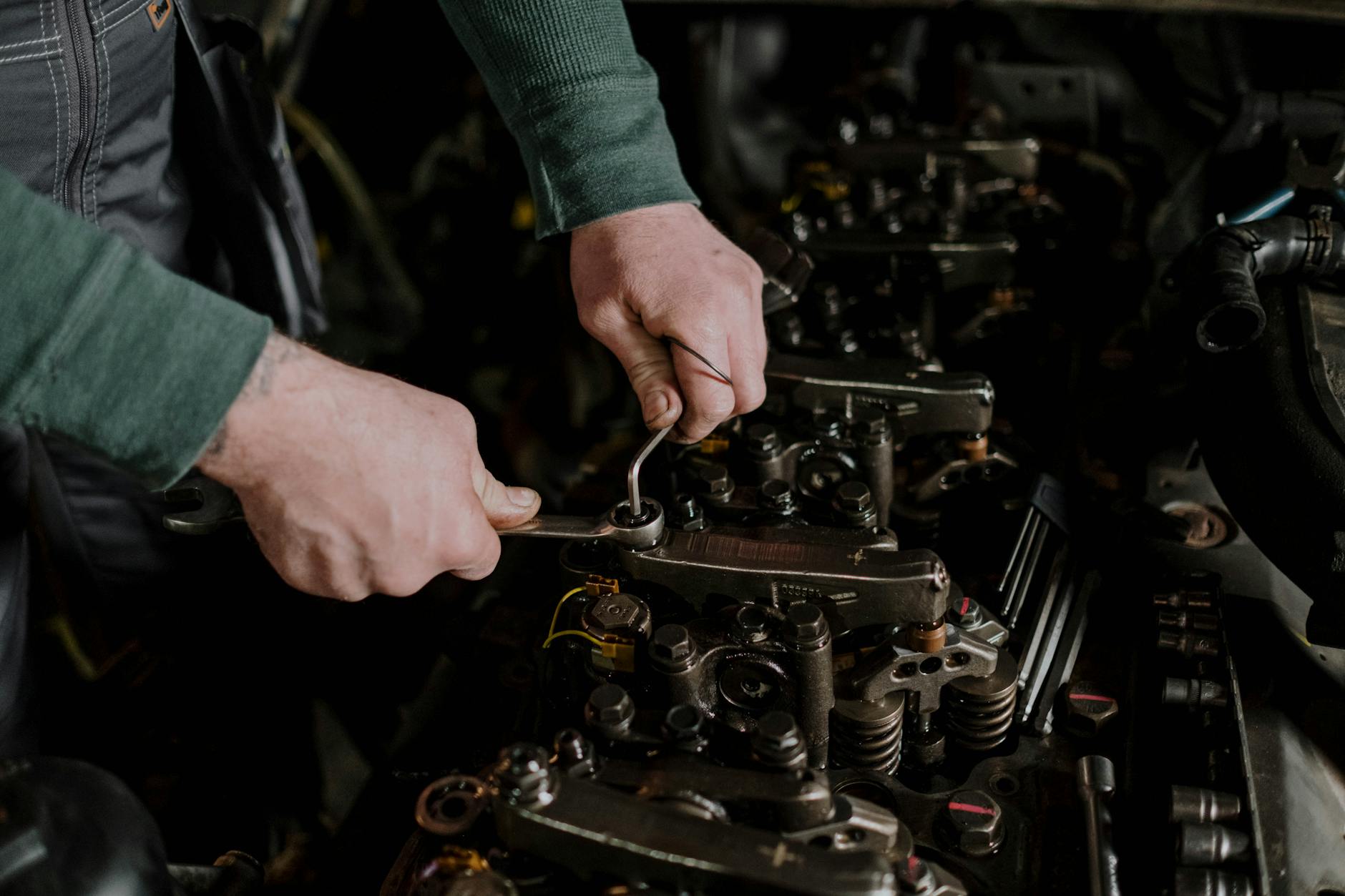 Auto technician inspecting engine components during preventive maintenance service at R & J Automotive Sun City AZ